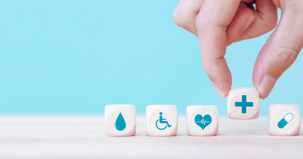 A hand is holding three dice with symbols on them.