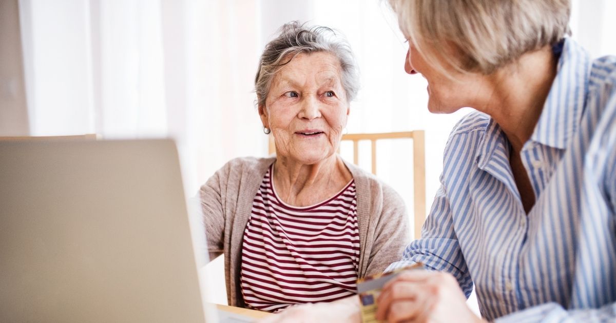 A woman and an older person are sitting at a table