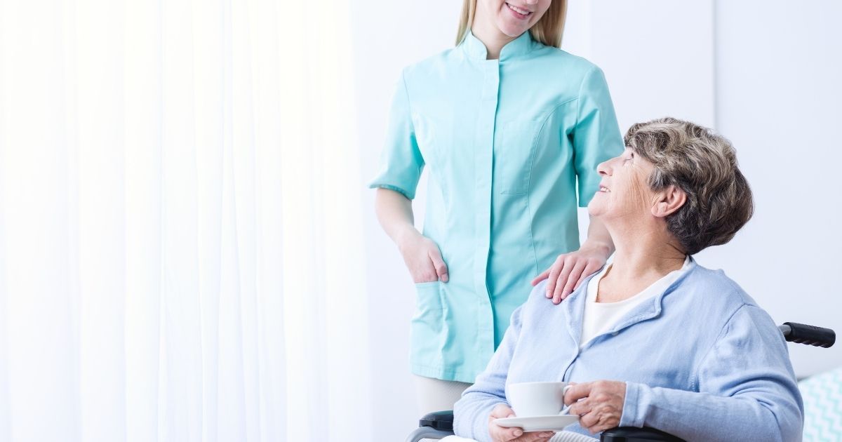 A woman standing next to an older person.